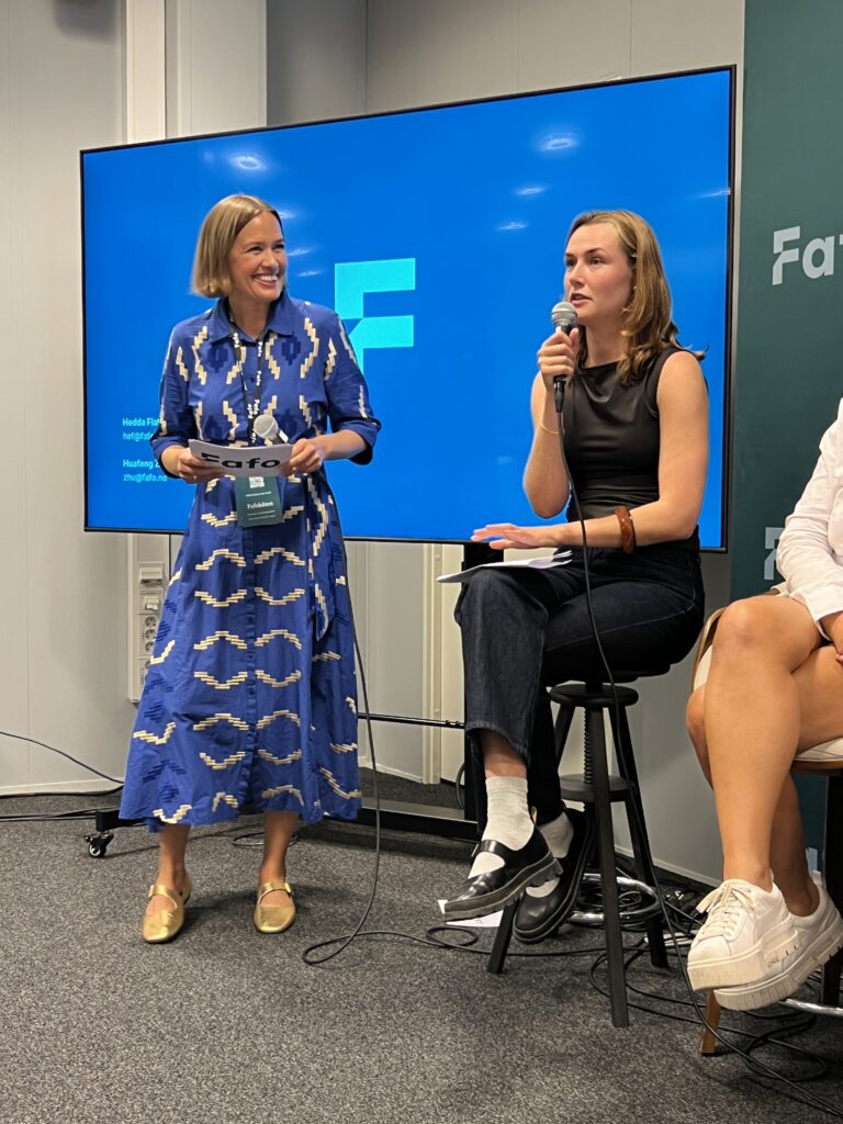 Fotografi av to kvinner, hvor den ene snakker inn i en mikrofon.